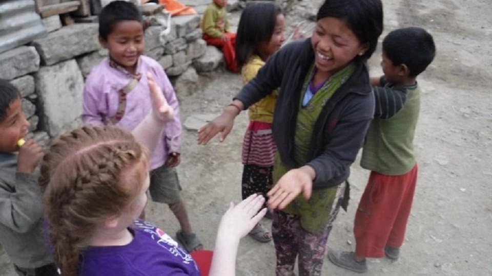 Mia playing with some children during her volunteering trip to Nepal. 