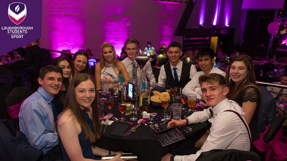 Elinor and her friends sitting at a table at the Athletic Union ball. 