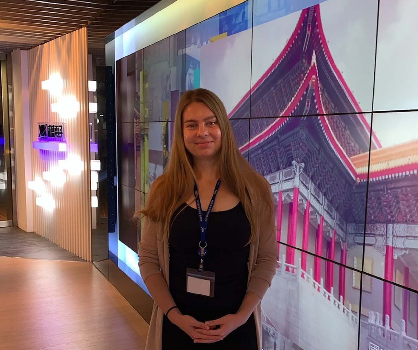 Photo of Simona in front of an LED screen at work.