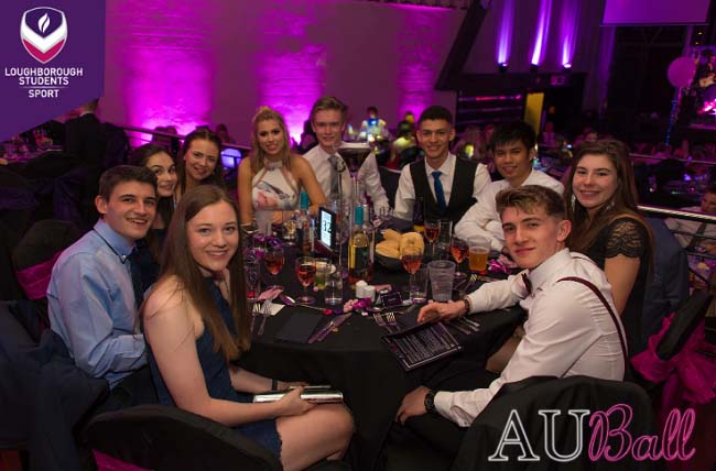 Eleanor and her friends sitting at a table at the Athletic Union ball.