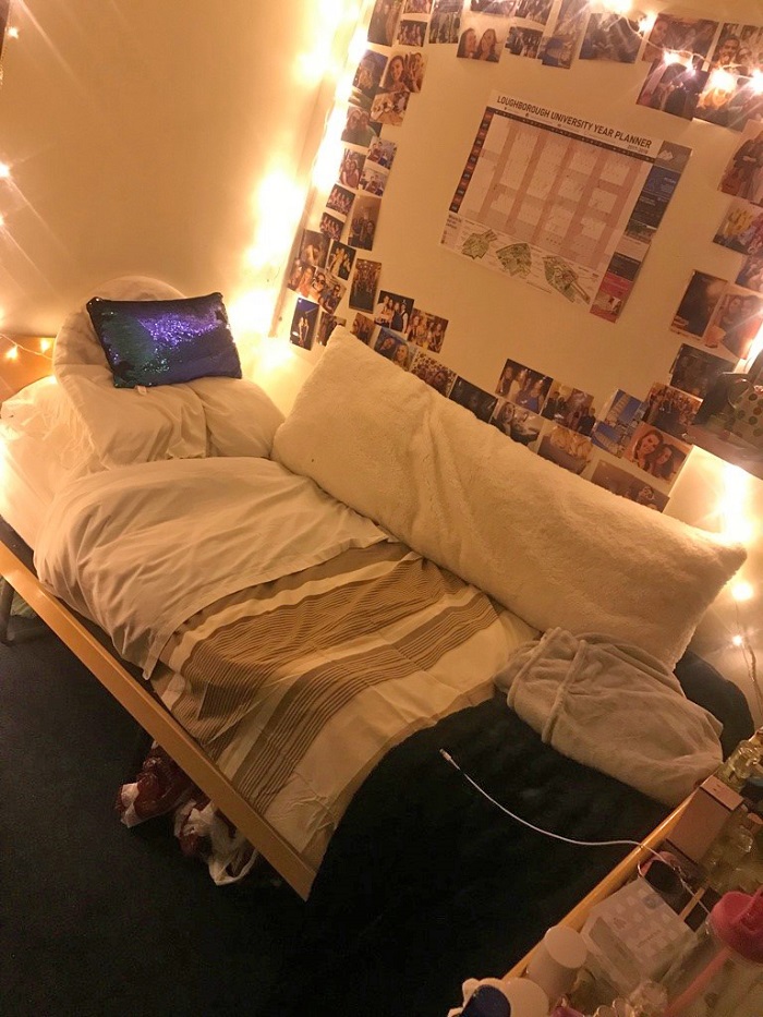 Caroline's room with her bed, photo wall and desk in shot.