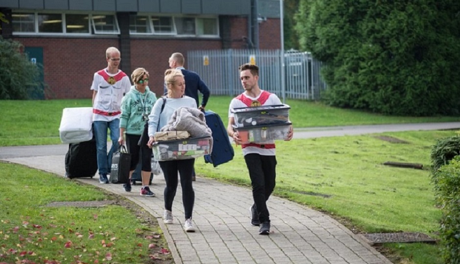 Image of a first year moving into Loughborough University Accommodation with two fresher helpers helping to carry their belongings.