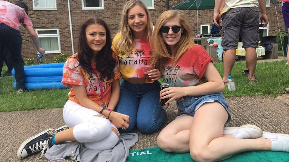 Niamh and two of her friends sitting on the ground at Faraday Hall day. 