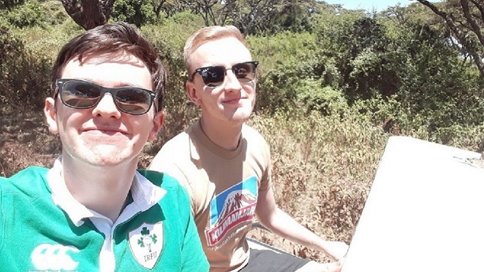 David wearing his Irish rugby top sitting next to a friend outside.