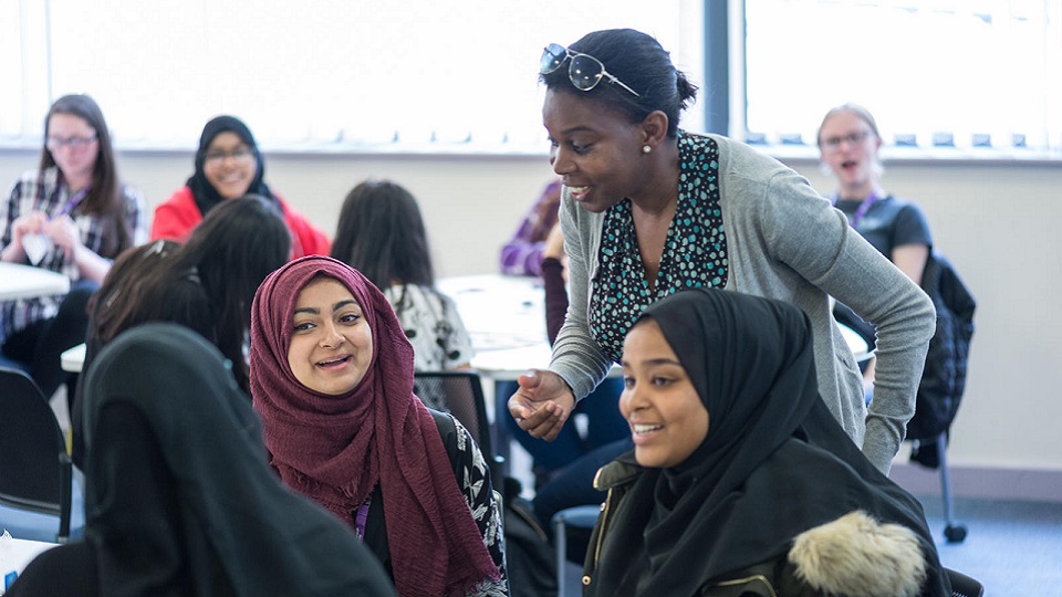 three female students talking to a lecturer