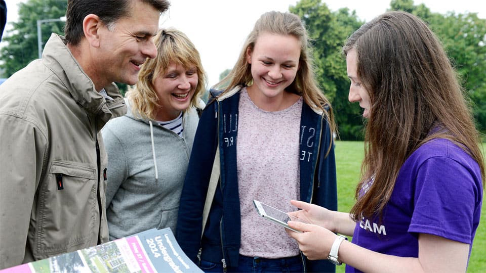 Two parents with their daughter talking to a student ambassador