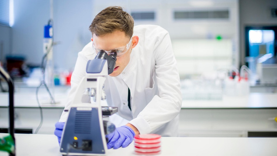 A student using a microscope in a laboratory.