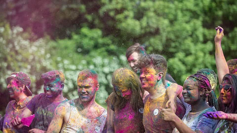 A group of students covered in brightly coloured paint taking part in a colour dash