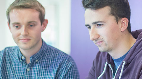 Two male students looking at a computer screen
