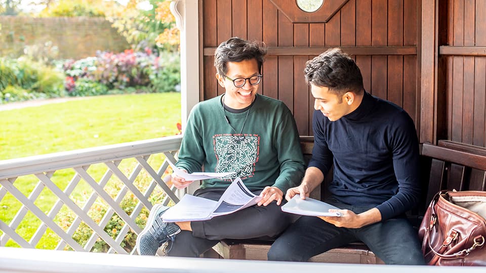 two male students studying outdoors
