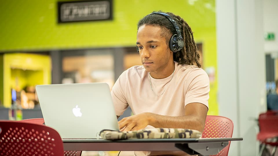 A student working with headphones on.