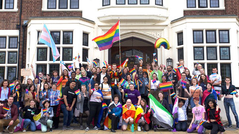 A group of staff and students with flags outside of the Hazlerigg building