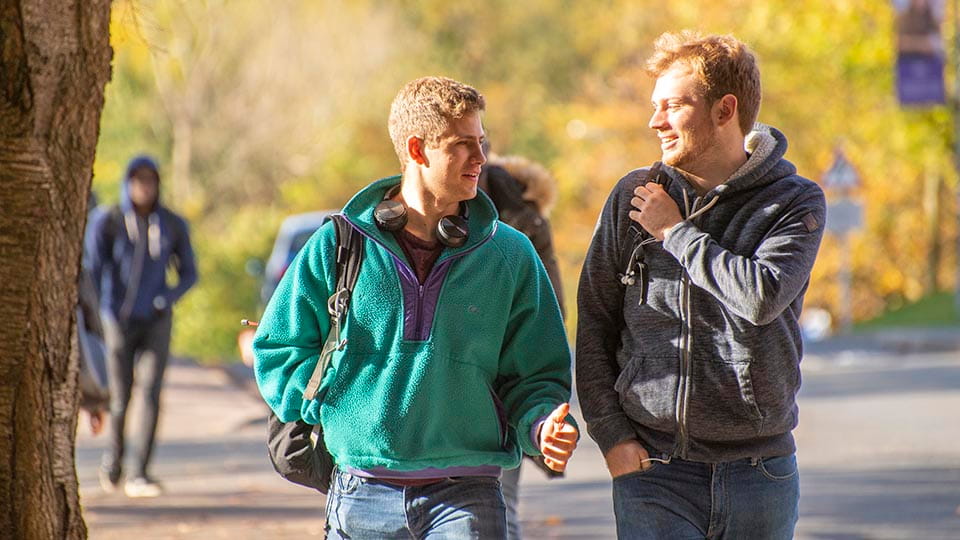 students with autumn trees in the background