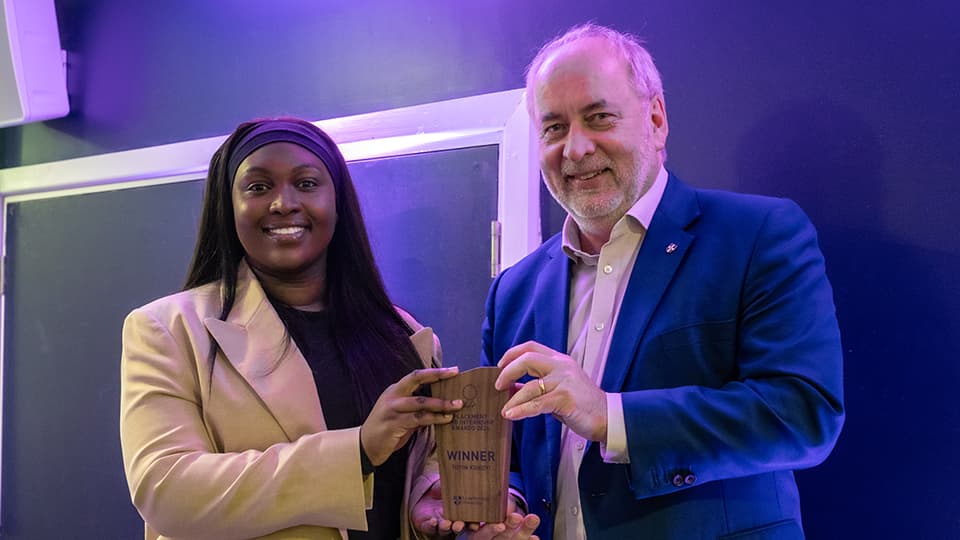 Toyin receiving an award from Nick Jennings.