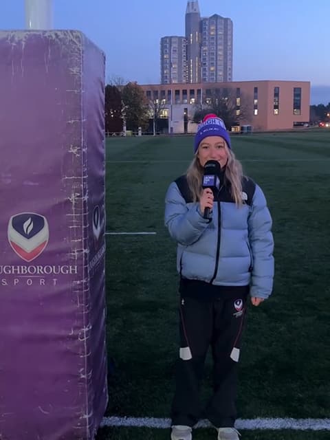 Bella Harris-Johnstone standing on a sports pitch holding a microphone.
