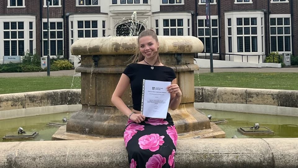 A female student stood in front of a fountain on Loughborough campus