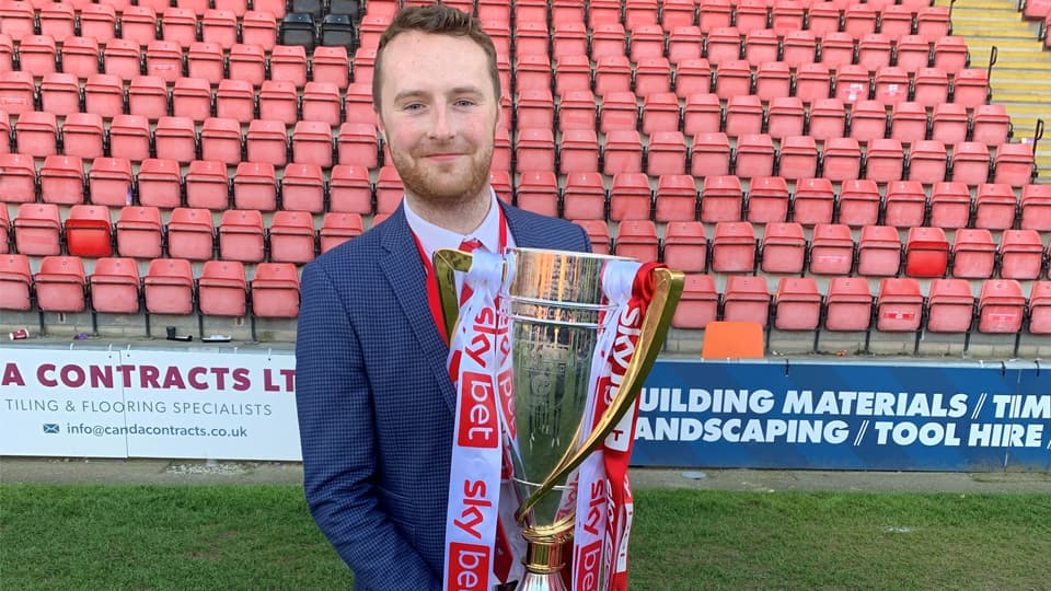 Tom Short holding a trophy on the stadium