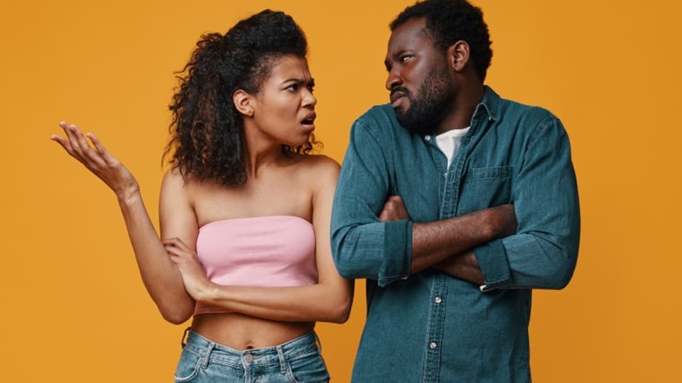 A couple arguing with an orange background