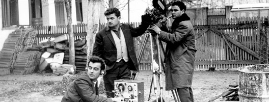 a camera operator, sound recordist and director standing together