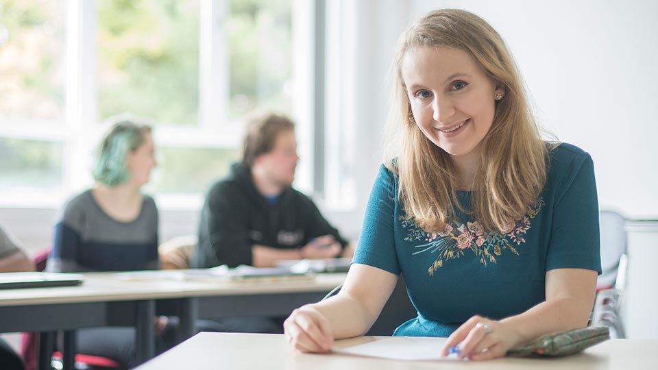 Hannah sat at a table holding a document