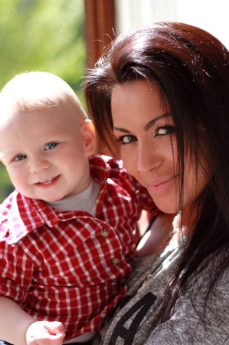 a mother holding a toddler wearing a red shirt