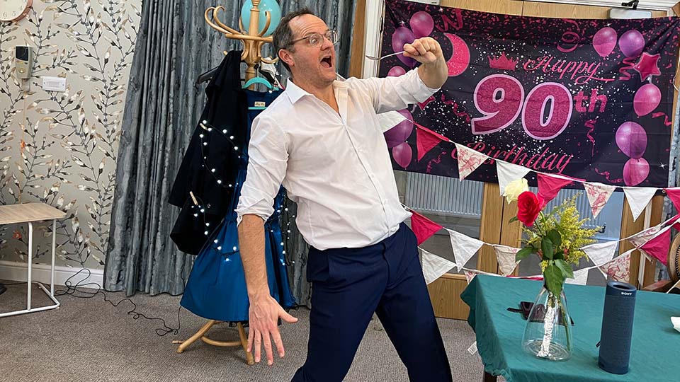 A man in a white shirt holding a spoon to his mouth