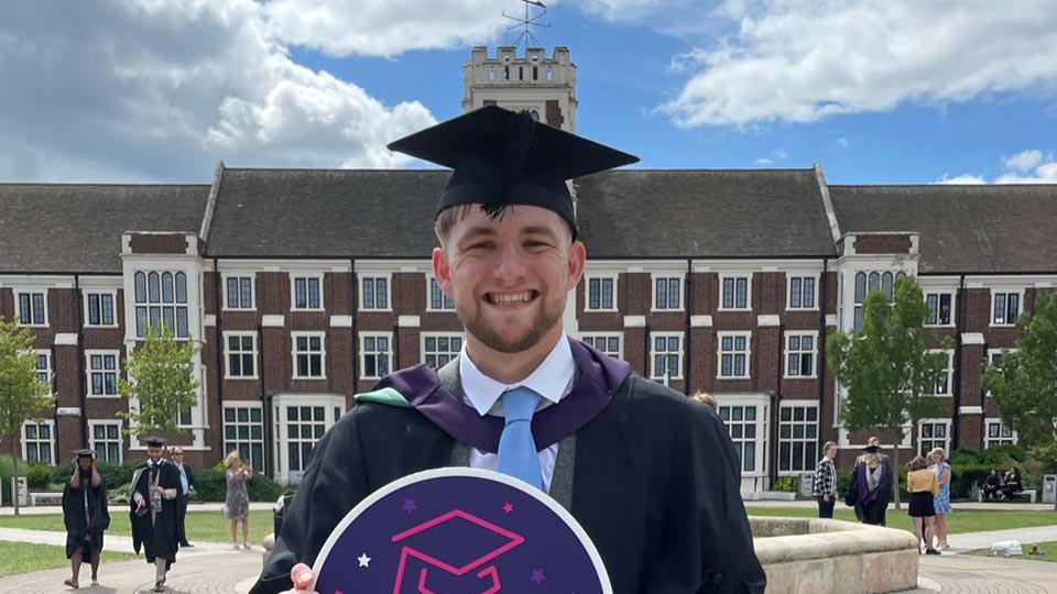 Kane stood outside wearing a graduation cap and gown