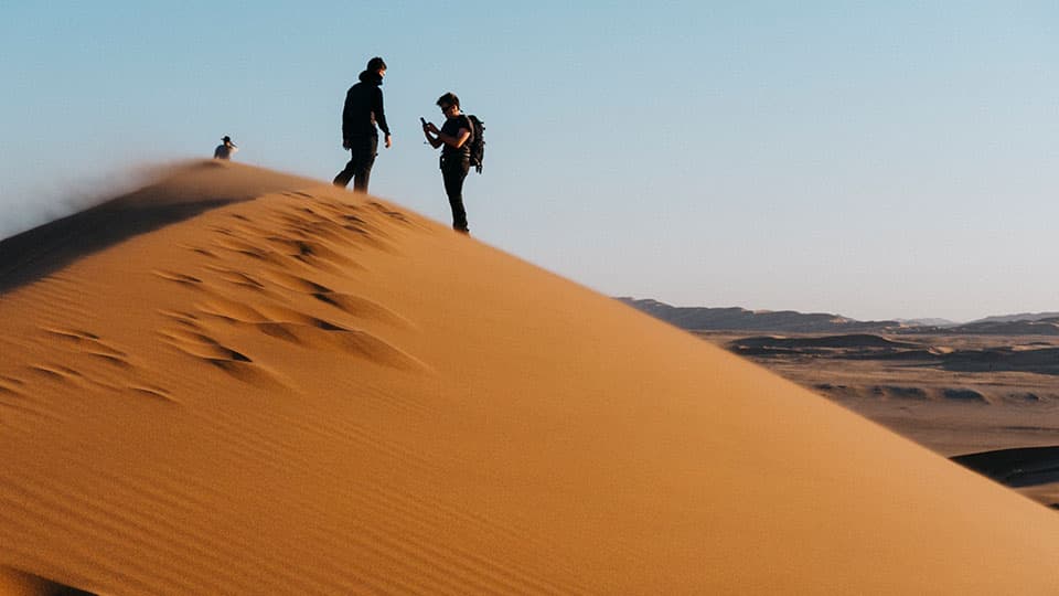 two people standing on a dune in Namibia