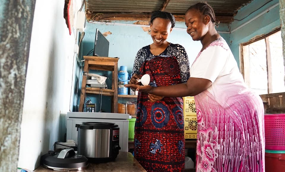two women in a kitchen preparing food