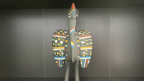 A black statue of a bird with colourful patterns