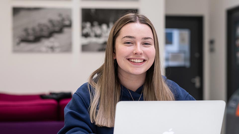 Ellen sat smiling with a laptop in front of her