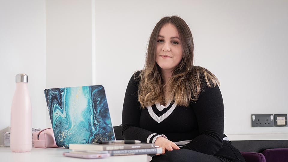 Livia sat at a table with a laptop open in front of her