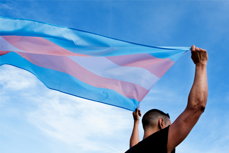 A young person waving the trans flag