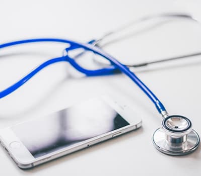 A stethoscope alongside a white smartphone.