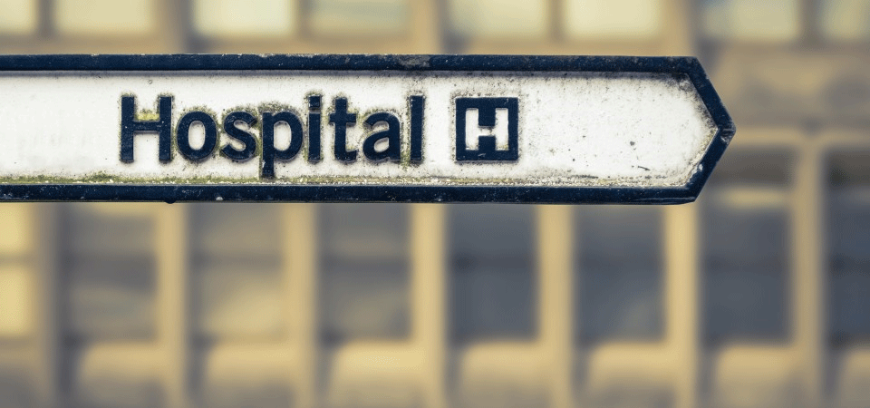 an old sign directing to a hospital