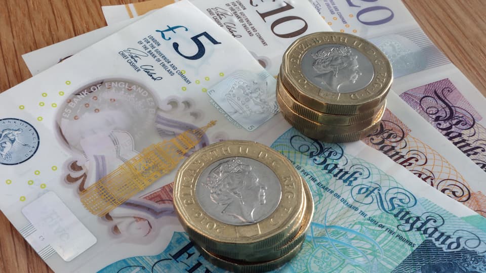 Pound coins on top of notes