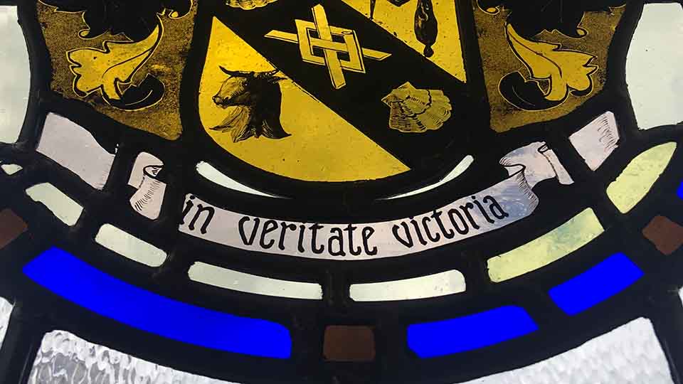 Stained glass bearing the Latin phrase 'in veritate victoria' (in truth, victory)