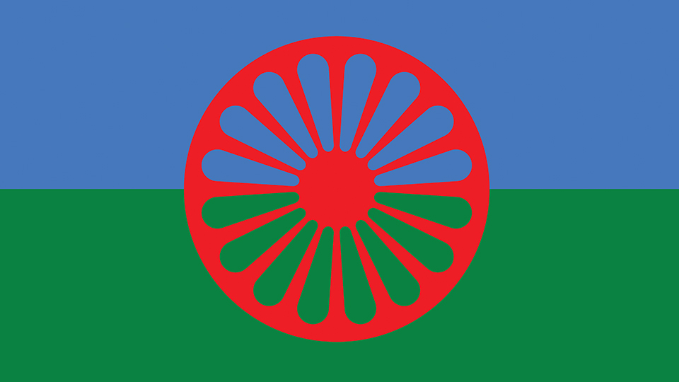 Blue and green striped flag with a red Chakra in the centre, the official emblem of the Roma