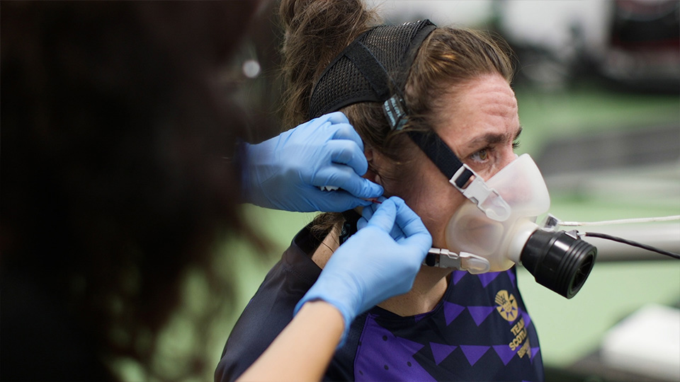 a breathing mask being fastened on to a woman's face