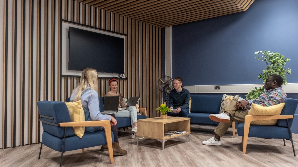 A group of founders smiling and chatting in the University's business incubator