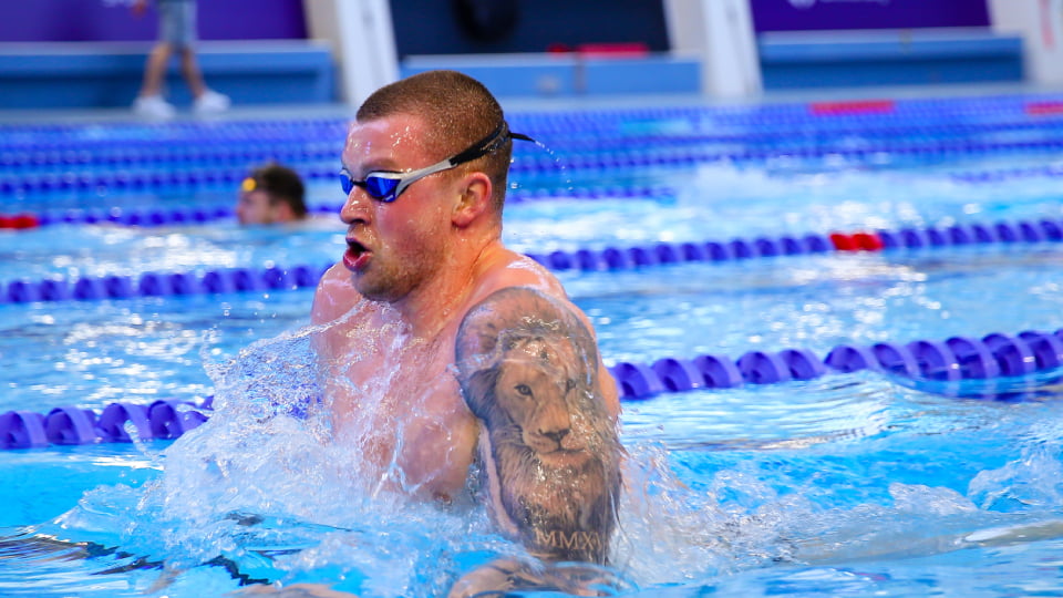 Adam Peaty swimming in a pool