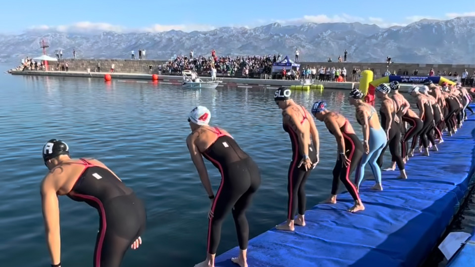 athletes on the starting line in an open water swim race