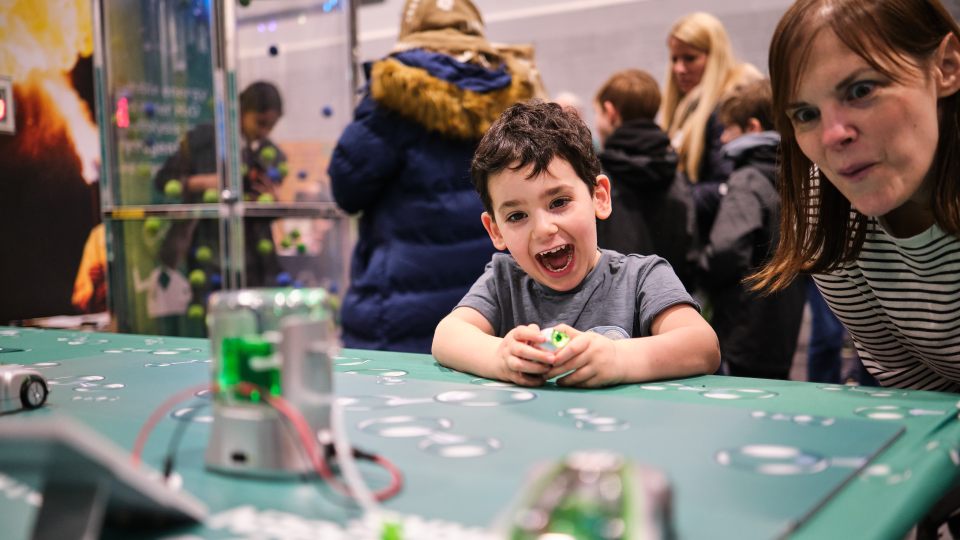 A child and an adult playing with some technology at the Green Hydrogen Festival.