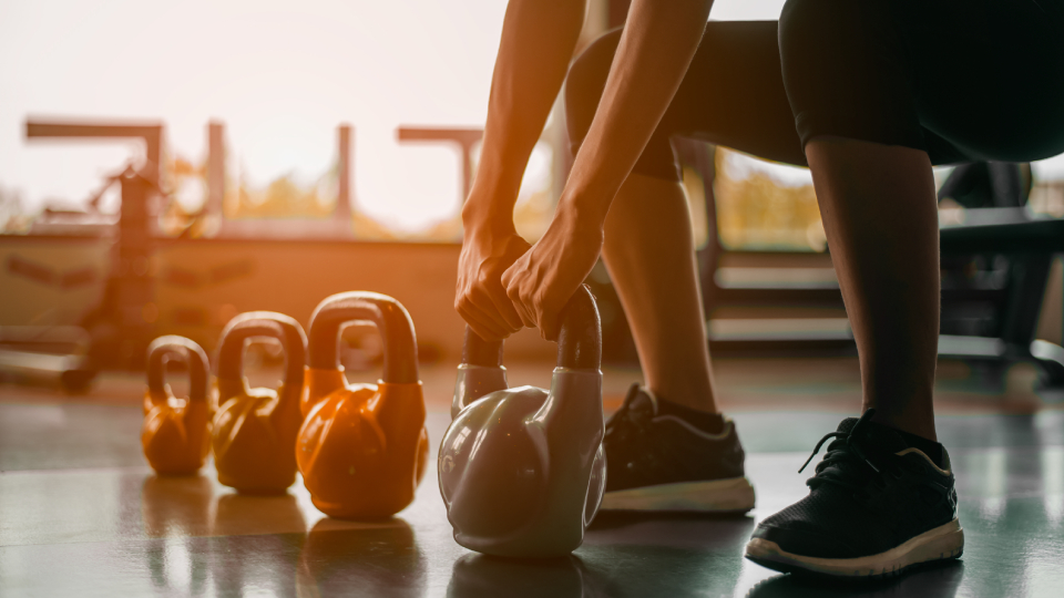 kettle bell weights in a row on the gym floor