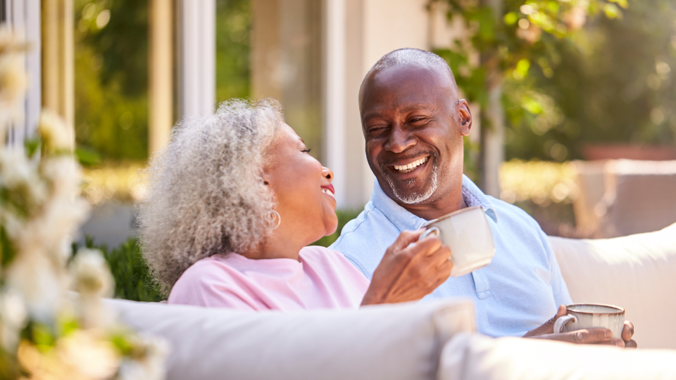 a couple smiling sharing a hot drink