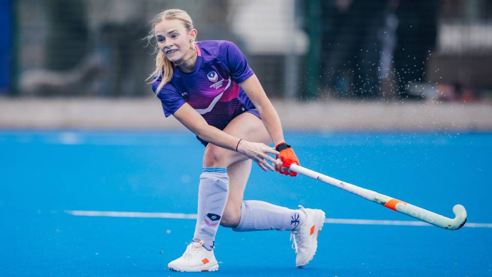 hockey player jess dyson strikes the ball