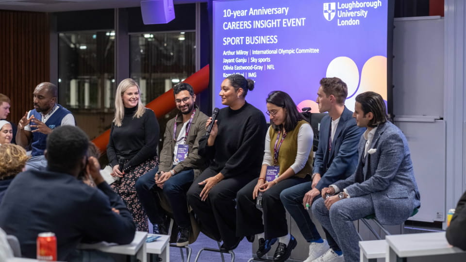 A panel of Loughborough University London alumni talking enthusiastically to an audience