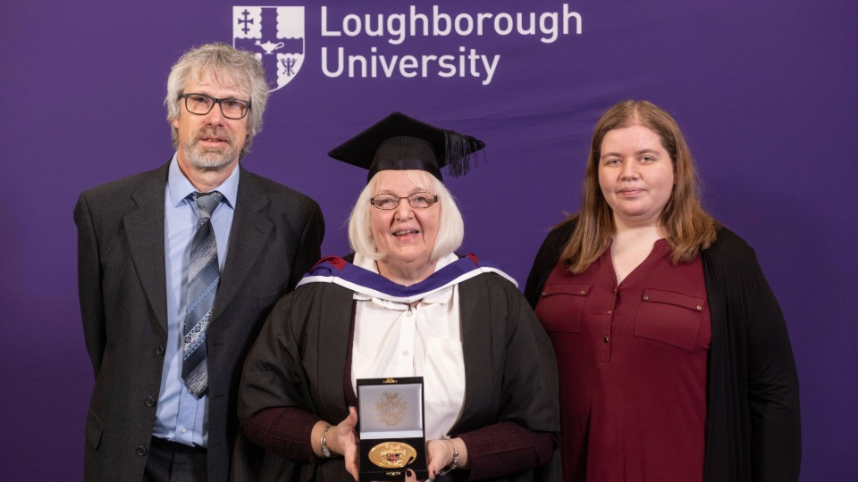 Pauline stood with family holding her University medal