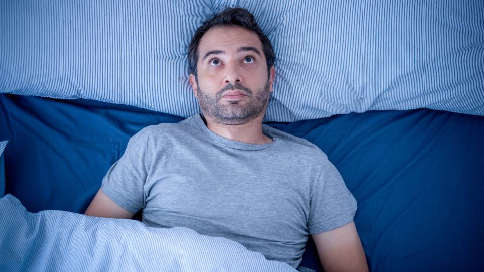 a man lying awake in bed