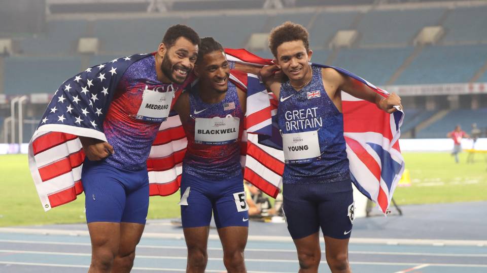 three athletes posed huddled for the camera